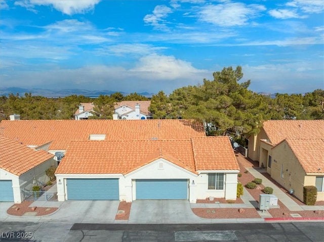 exterior space with a tiled roof, an attached garage, driveway, and stucco siding