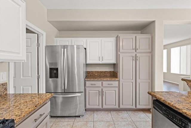 kitchen featuring white cabinetry, stainless steel appliances, light stone countertops, and light tile patterned flooring