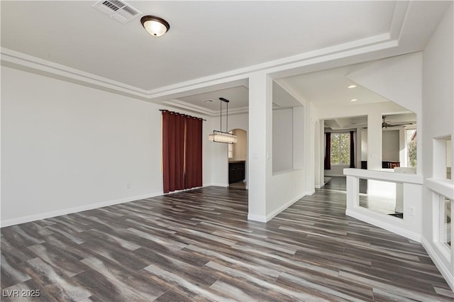 spare room with crown molding and dark wood-type flooring