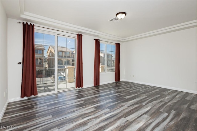 empty room with a healthy amount of sunlight and dark hardwood / wood-style flooring