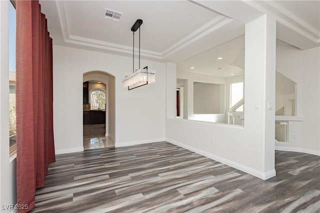 unfurnished dining area with dark hardwood / wood-style flooring and a tray ceiling