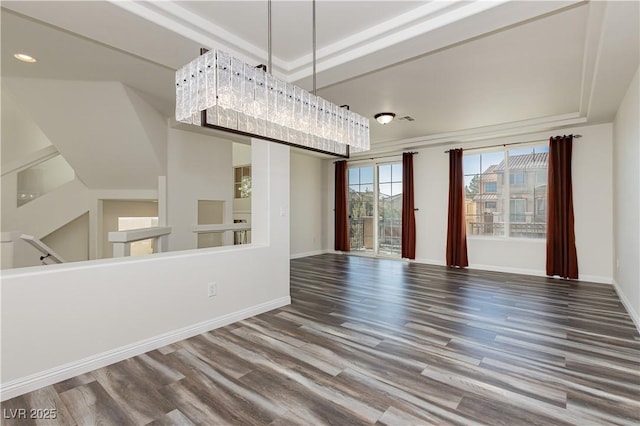 unfurnished dining area featuring hardwood / wood-style floors and a tray ceiling