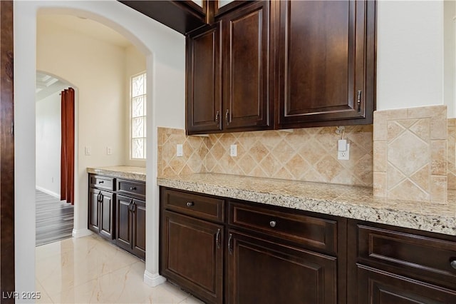 kitchen featuring dark brown cabinetry and decorative backsplash