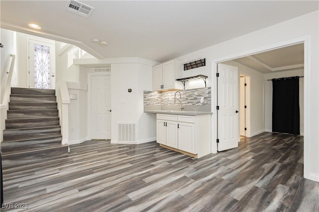 kitchen featuring white cabinetry, wood-type flooring, sink, and decorative backsplash