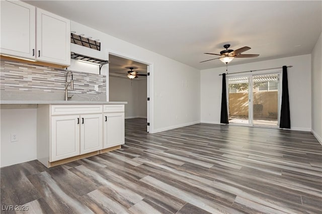 unfurnished living room featuring sink, dark hardwood / wood-style floors, and ceiling fan