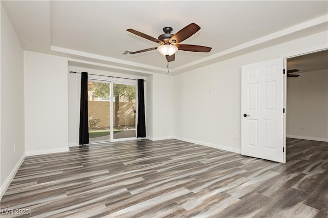 spare room featuring a raised ceiling, hardwood / wood-style flooring, and ceiling fan