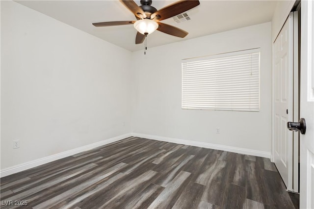 spare room with dark hardwood / wood-style flooring and ceiling fan