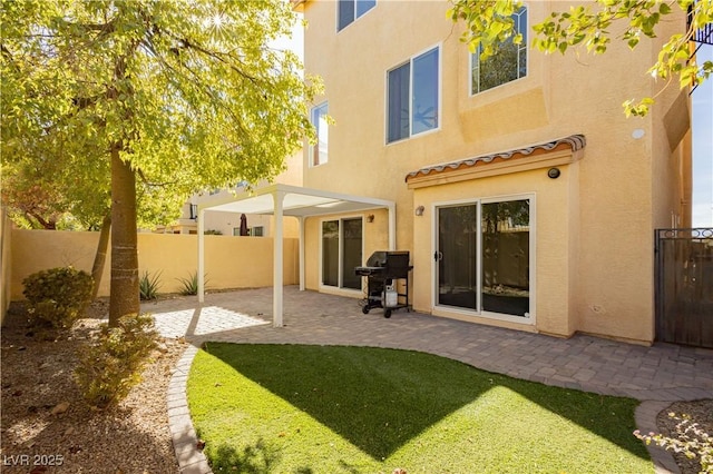 rear view of house with a patio area and a lawn