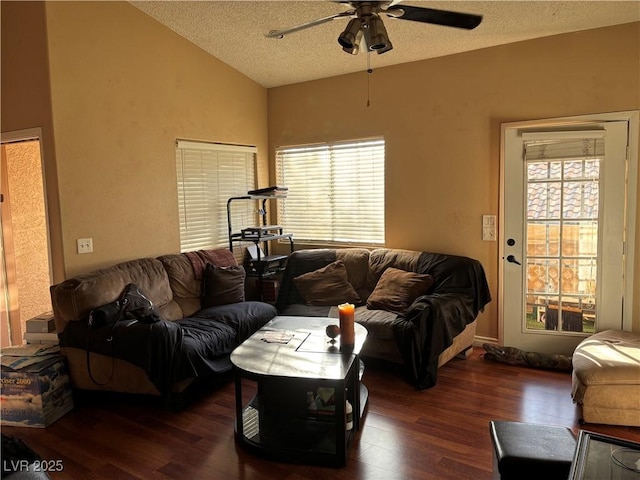 living room featuring ceiling fan, lofted ceiling, dark wood-type flooring, and a textured ceiling