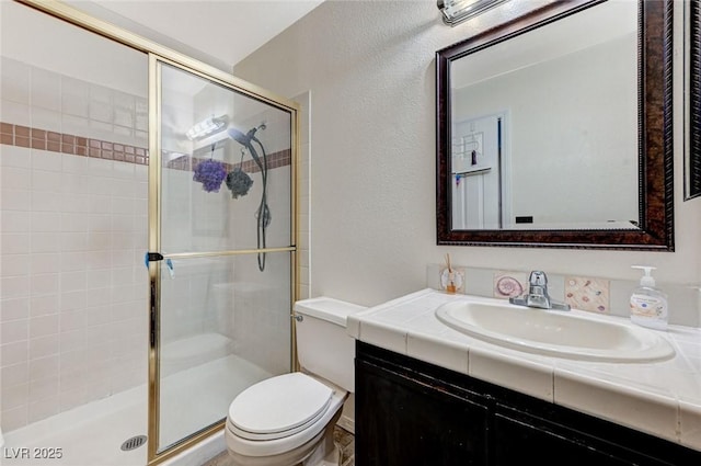 full bath with a stall shower, a textured wall, vanity, and toilet