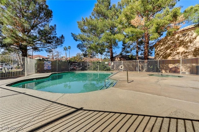 community pool featuring a patio area, fence, and a hot tub