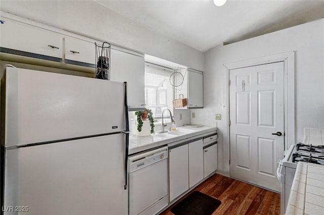 kitchen featuring white appliances, a sink, tile countertops, and dark wood-style flooring