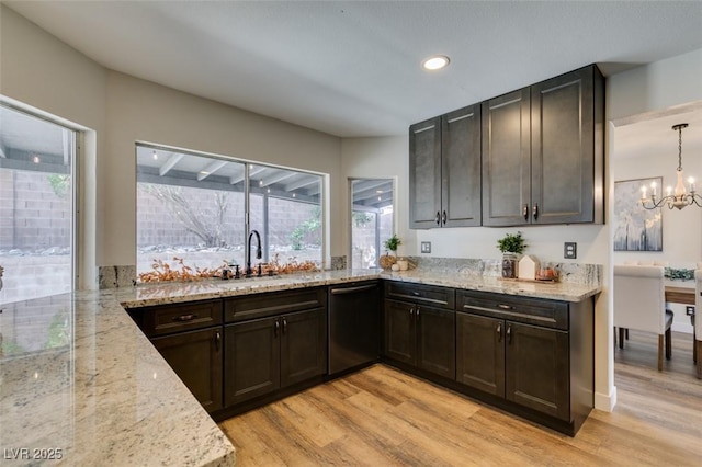 kitchen featuring sink, light hardwood / wood-style flooring, black dishwasher, light stone counters, and decorative light fixtures