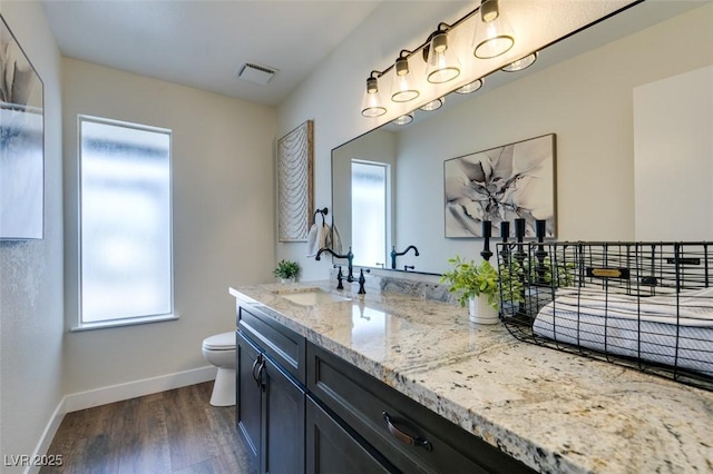 bathroom with hardwood / wood-style flooring, vanity, and toilet