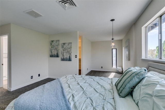 bedroom with ensuite bath and dark colored carpet