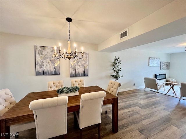 dining space featuring wood-type flooring and a chandelier