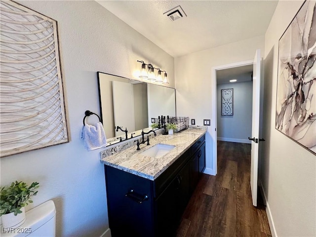 bathroom with vanity, hardwood / wood-style flooring, and toilet