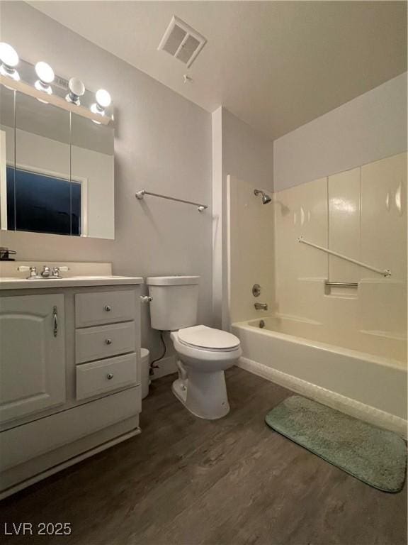 full bathroom featuring wood-type flooring, toilet, tub / shower combination, and vanity