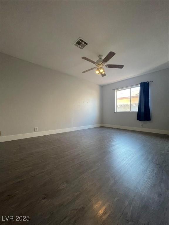 spare room featuring dark wood-type flooring and ceiling fan