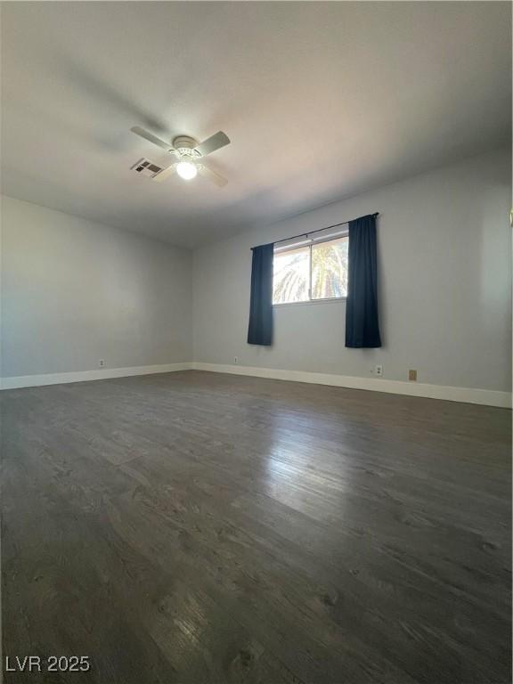 unfurnished room featuring ceiling fan and dark hardwood / wood-style flooring