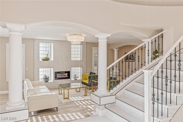 living room featuring a fireplace, hardwood / wood-style floors, and ornate columns