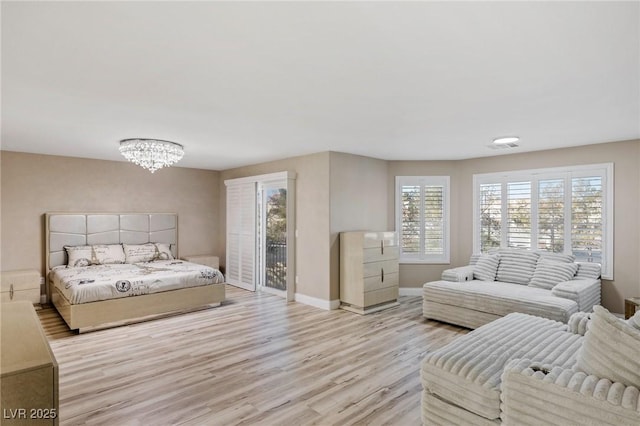 bedroom with access to exterior, a chandelier, and light hardwood / wood-style floors