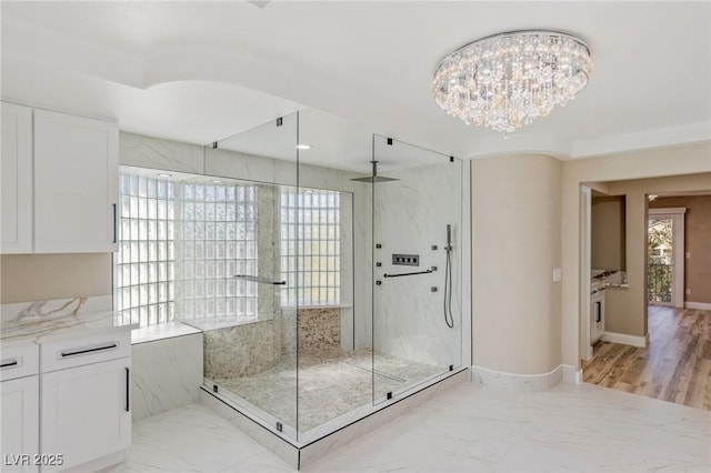 bathroom featuring tiled shower and an inviting chandelier