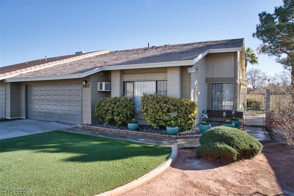 single story home featuring a garage, a wall mounted AC, and a front yard