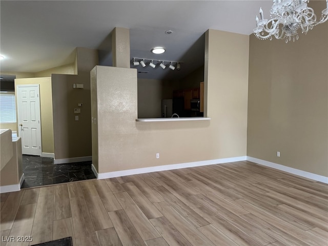 interior space featuring lofted ceiling, hardwood / wood-style floors, and an inviting chandelier