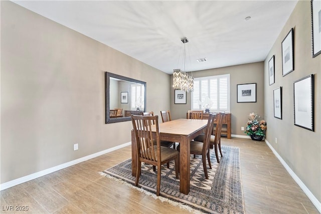 dining room featuring a chandelier and light wood-type flooring