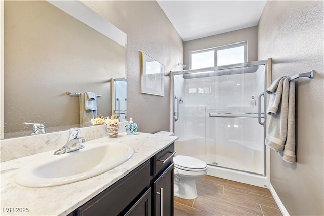 bathroom featuring vanity, an enclosed shower, and toilet