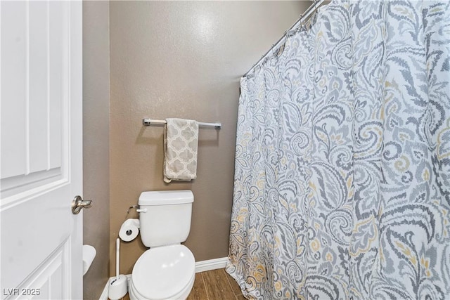 bathroom featuring wood-type flooring and toilet