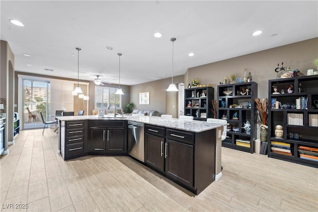 kitchen with dishwasher, pendant lighting, and an island with sink