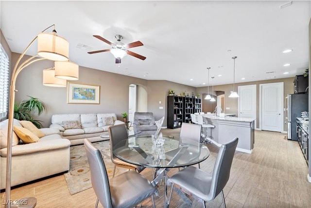 dining space with light hardwood / wood-style flooring and ceiling fan