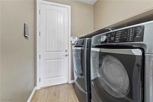 washroom featuring washer and clothes dryer and light hardwood / wood-style flooring