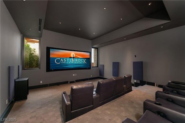 carpeted cinema with a raised ceiling