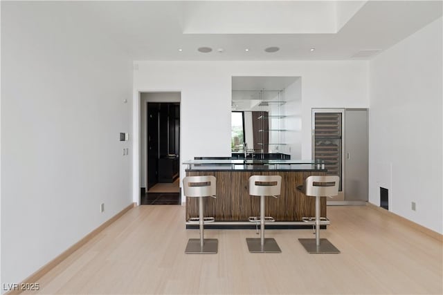 kitchen with a kitchen bar and light wood-type flooring