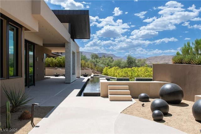 view of patio / terrace with a mountain view and a swimming pool