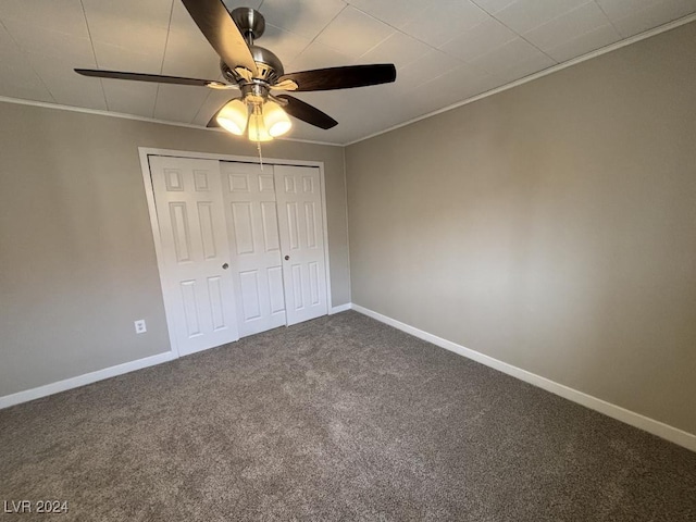 unfurnished bedroom with ceiling fan, ornamental molding, carpet floors, and a closet