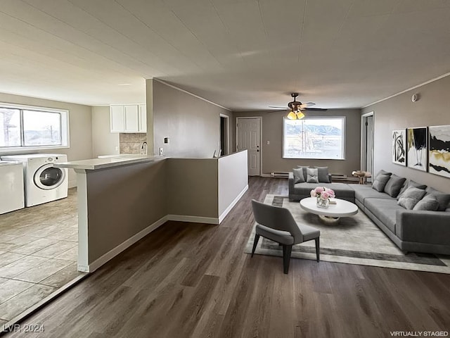 living room featuring washer and dryer, dark hardwood / wood-style floors, a wealth of natural light, and ceiling fan