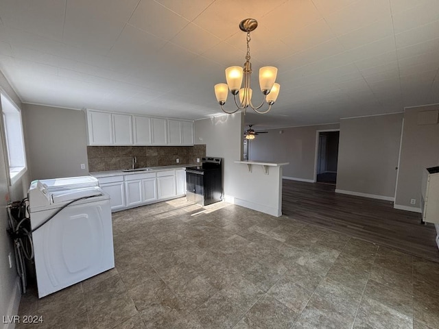 kitchen featuring washer / dryer, sink, white cabinetry, range with electric cooktop, and decorative backsplash