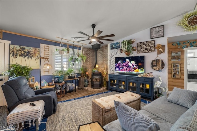 living room with ceiling fan, hardwood / wood-style floors, and a wood stove