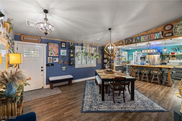 dining space featuring lofted ceiling, dark wood-type flooring, and an inviting chandelier