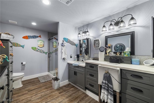 bathroom featuring vanity, toilet, an enclosed shower, and hardwood / wood-style floors