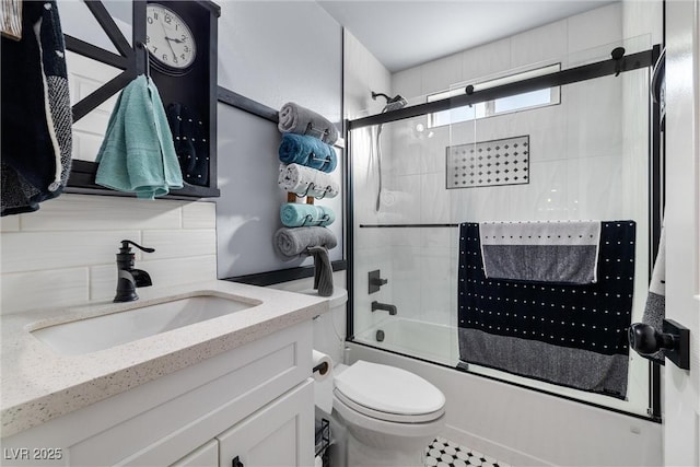 full bathroom with toilet, vanity, bath / shower combo with glass door, and backsplash