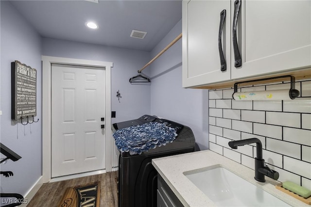 laundry area featuring cabinets, washer / clothes dryer, dark hardwood / wood-style flooring, and sink