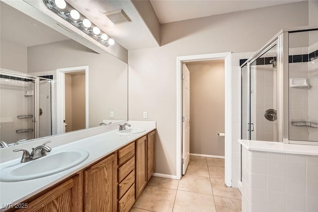 bathroom featuring an enclosed shower, vanity, and tile patterned floors