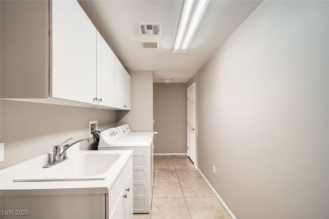 laundry area with light tile patterned flooring, cabinets, sink, and washer and dryer