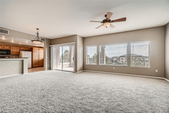 unfurnished living room with light carpet and ceiling fan