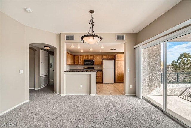 kitchen with white refrigerator, range, light carpet, and pendant lighting